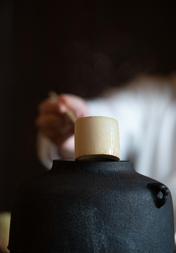 茶釜から柄杓で湯を汲む