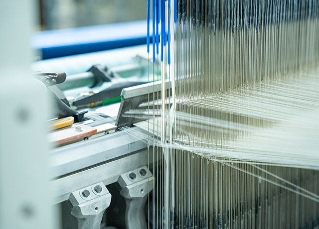 8,000本の細い糸を複雑に上下させながら、4層の生地をまとめて織りあげる。