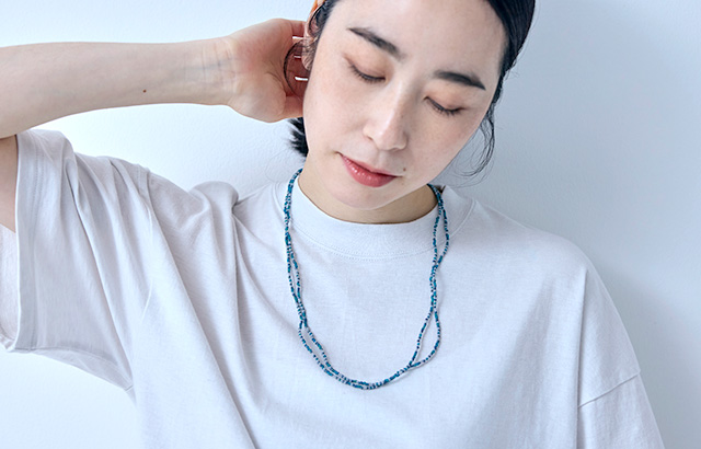 胸元に涼しげな表情を添えるアクセサリー